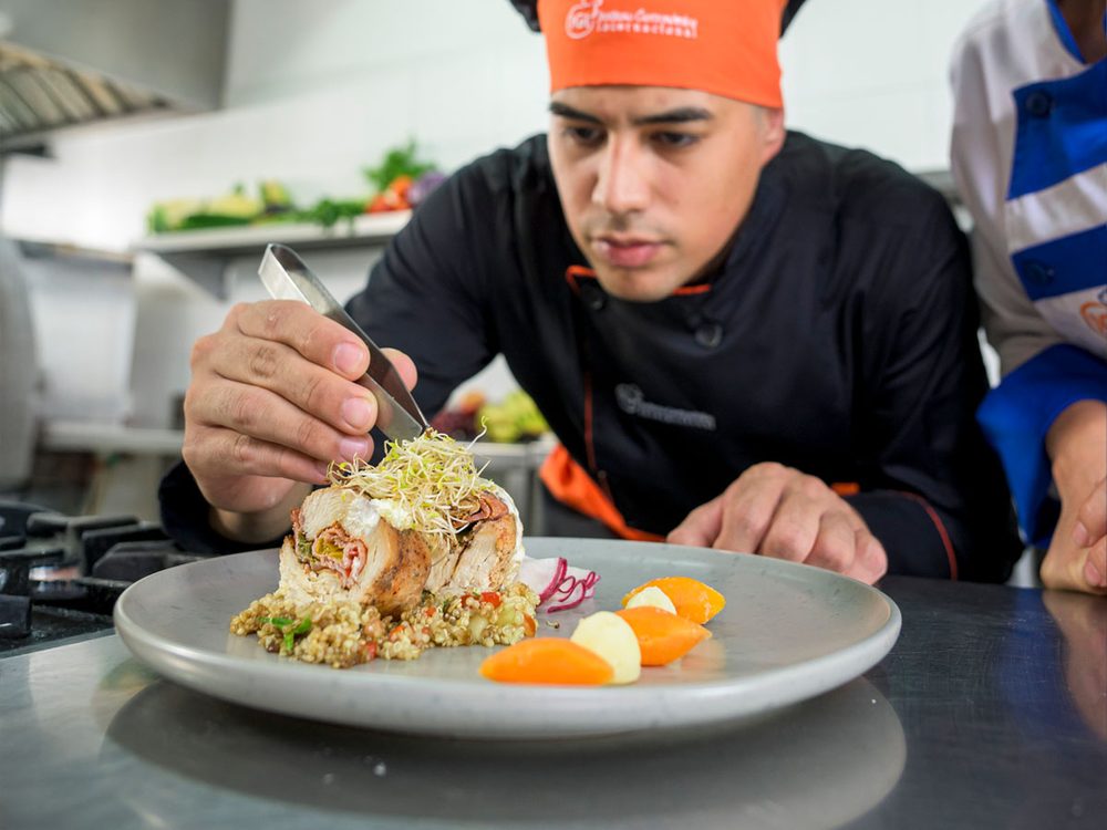 Chef profesional emplatando un plato en una cocina de IGI